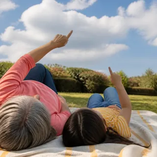 A family lying on the grass pointing at the sky