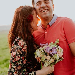 A smiling couple with a bouquet of flowers
