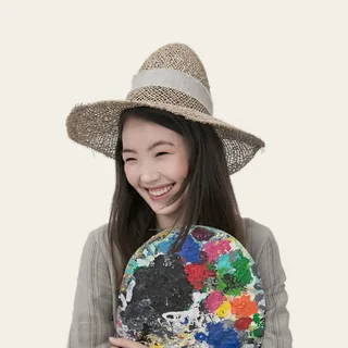 A young woman in a straw hat laughing